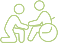 Outline icon of person kneeling beside another person in a wheelchair, symbolizing assistance.